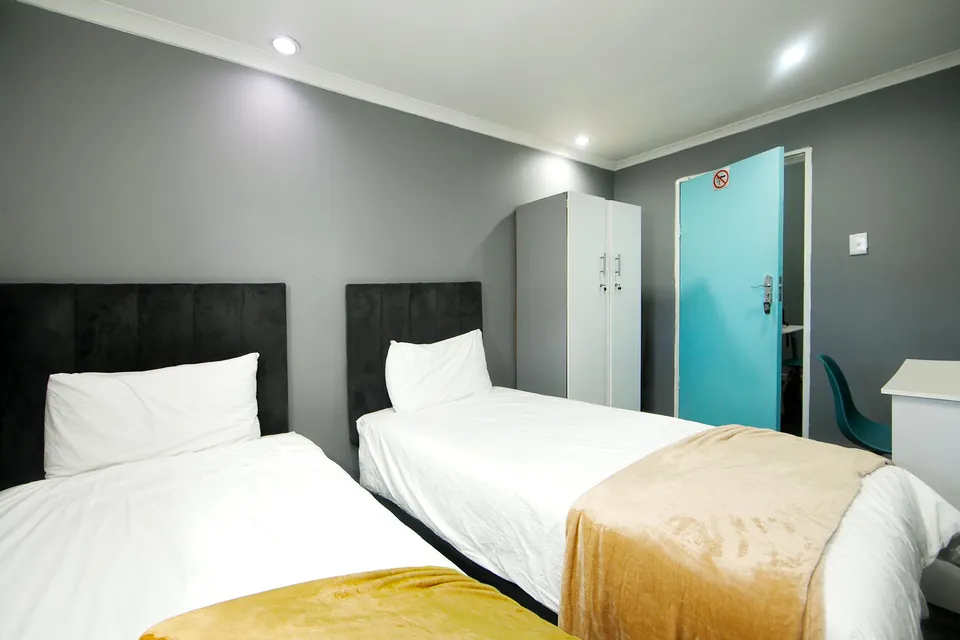 Two single beds with white linen and mustard throws