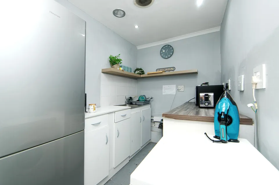 Guest kitchenette with fridge and iron